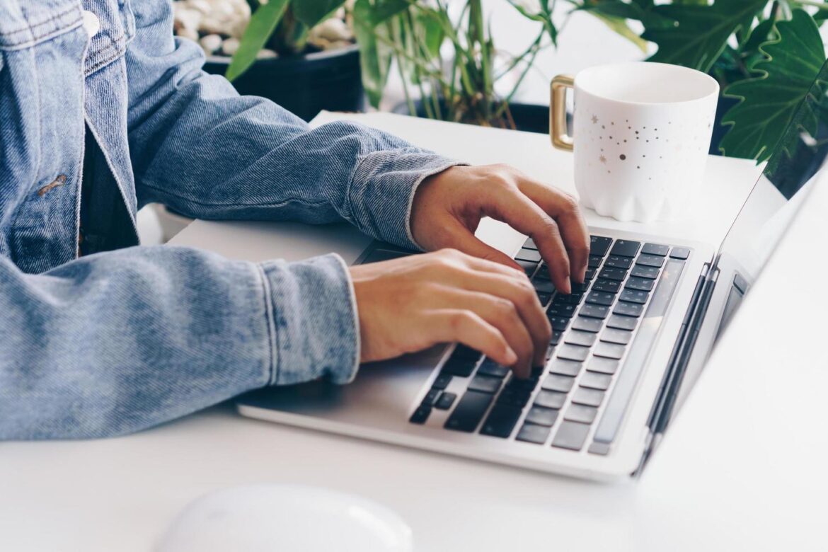 person-using-a-laptop-to-study-on-work-desk-free-photo